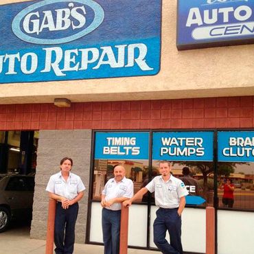 Three men standing in front of gab 's auto repair