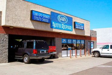 Two cars are parked in front of gab 's auto repair