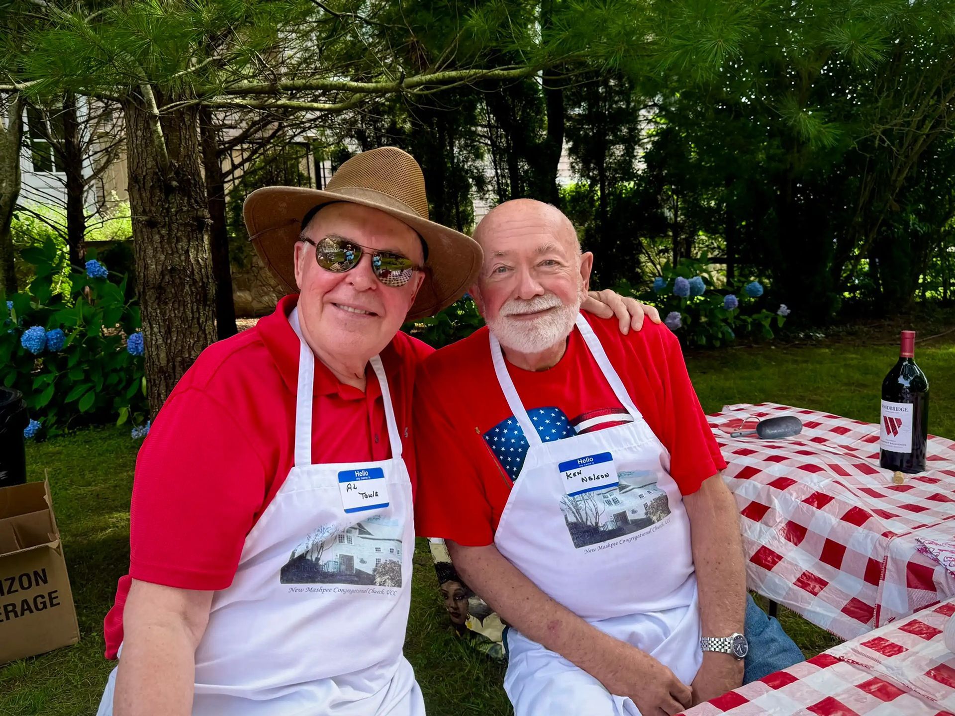 two men wearing red shirts and an aprons for cooking
