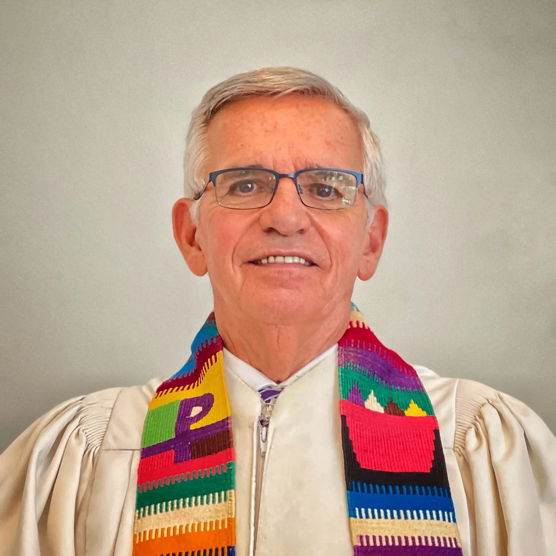 man wearing glasses and a colorful scarf 
