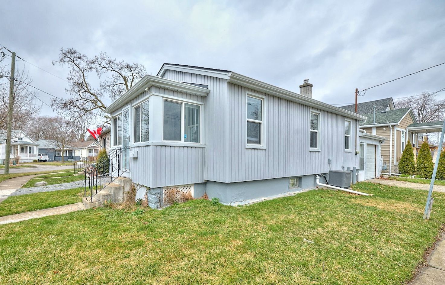 A blue detached bungalow located in North St. Catharines, Ontario.