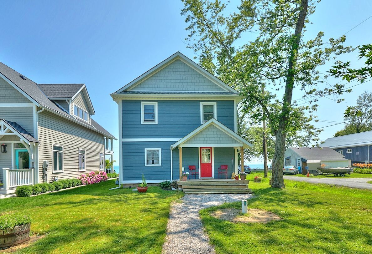 A picturesque photo of a blue residential house with a touch of architectural beauty