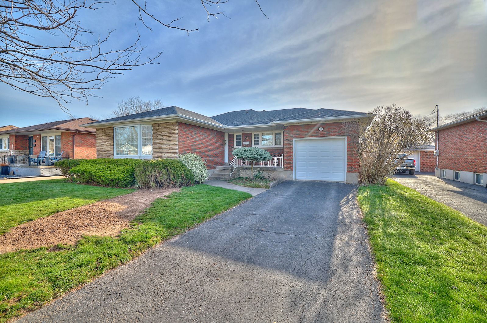 A well-maintained brick and stone bungalow with an attached garage.