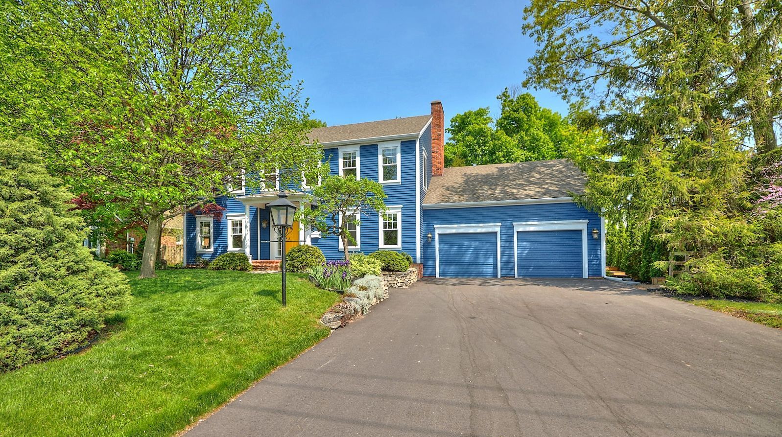A picturesque photo of a blue residential house with a touch of architectural beauty
