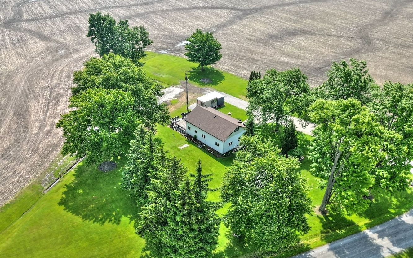 Surrounded by open farmland, at the end of the road.