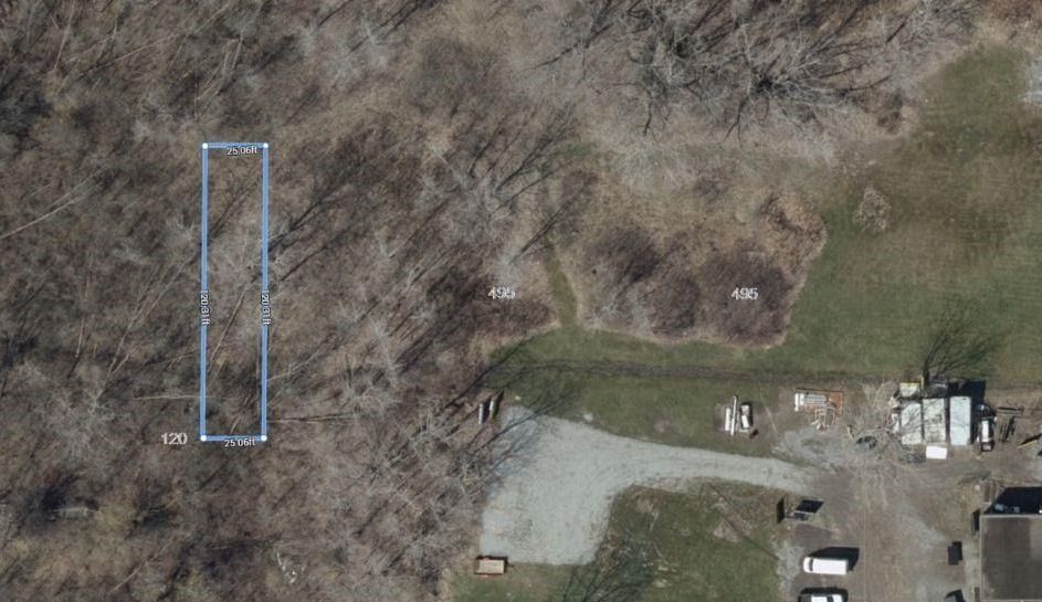 Picture of vacant commercial land in Welland, bordered by trees and featuring unopened road allowance.