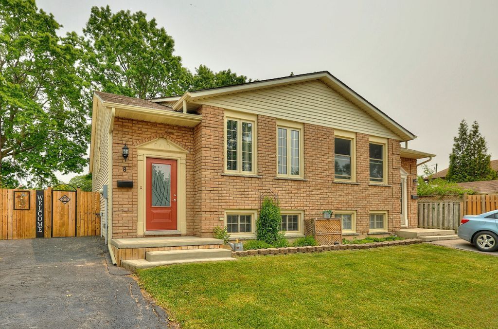 A picture of a brick semi-detached brick home with a red front door.