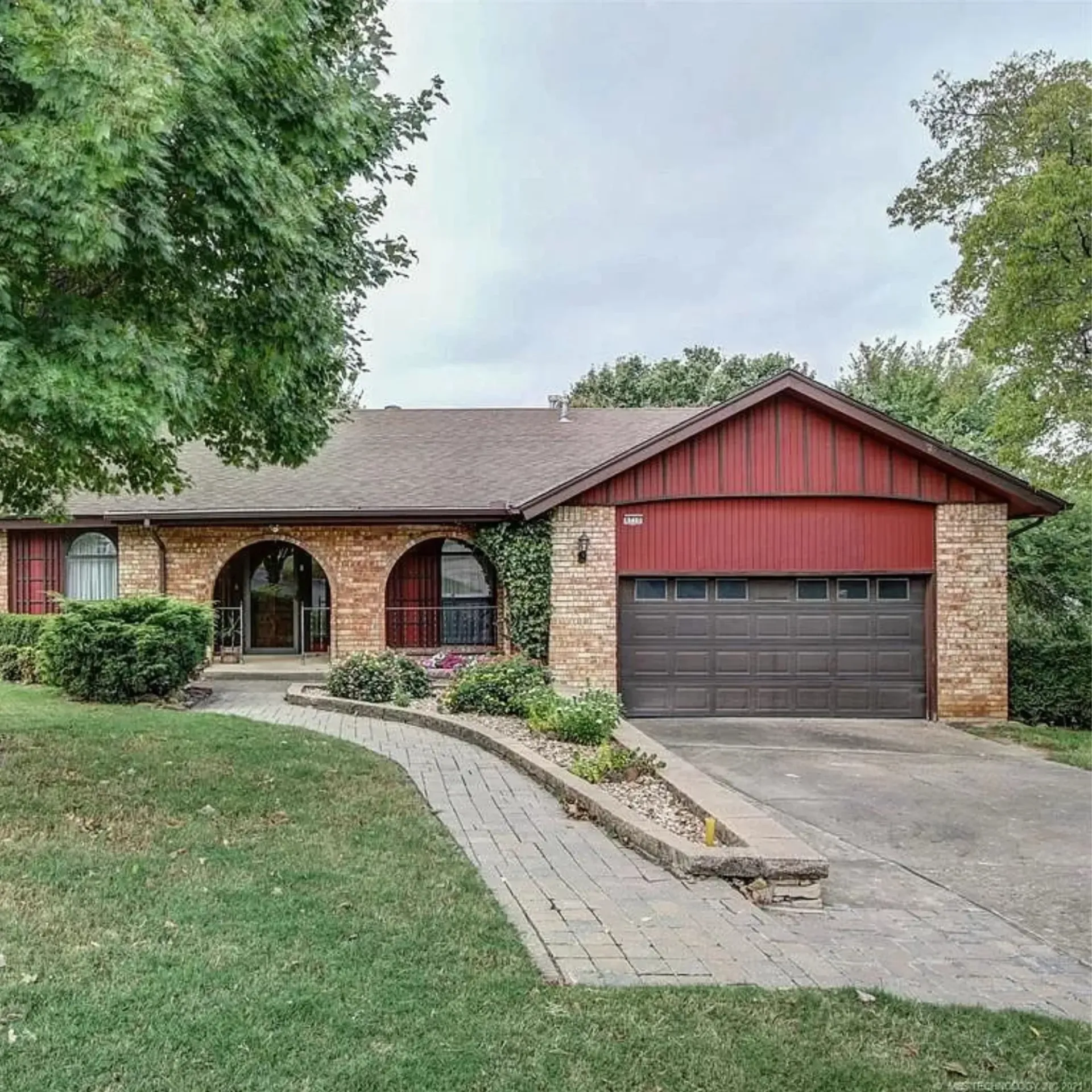 Aarons Repair and Remodel - A brick house with a red garage door