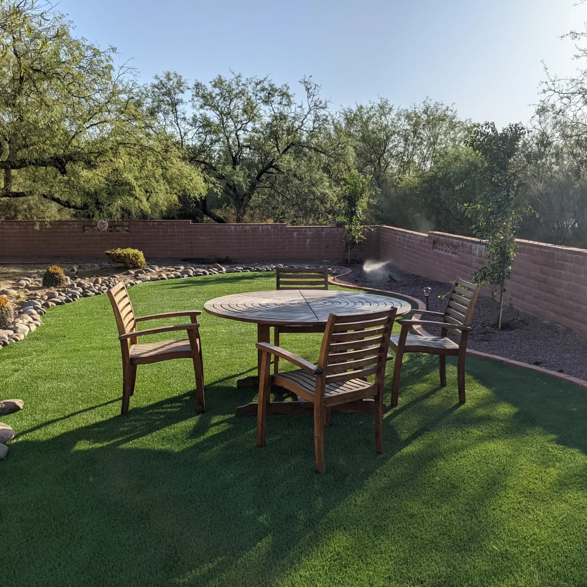 Aarons Repair and Remodel - A table and chairs are sitting on top of a lush green lawn.