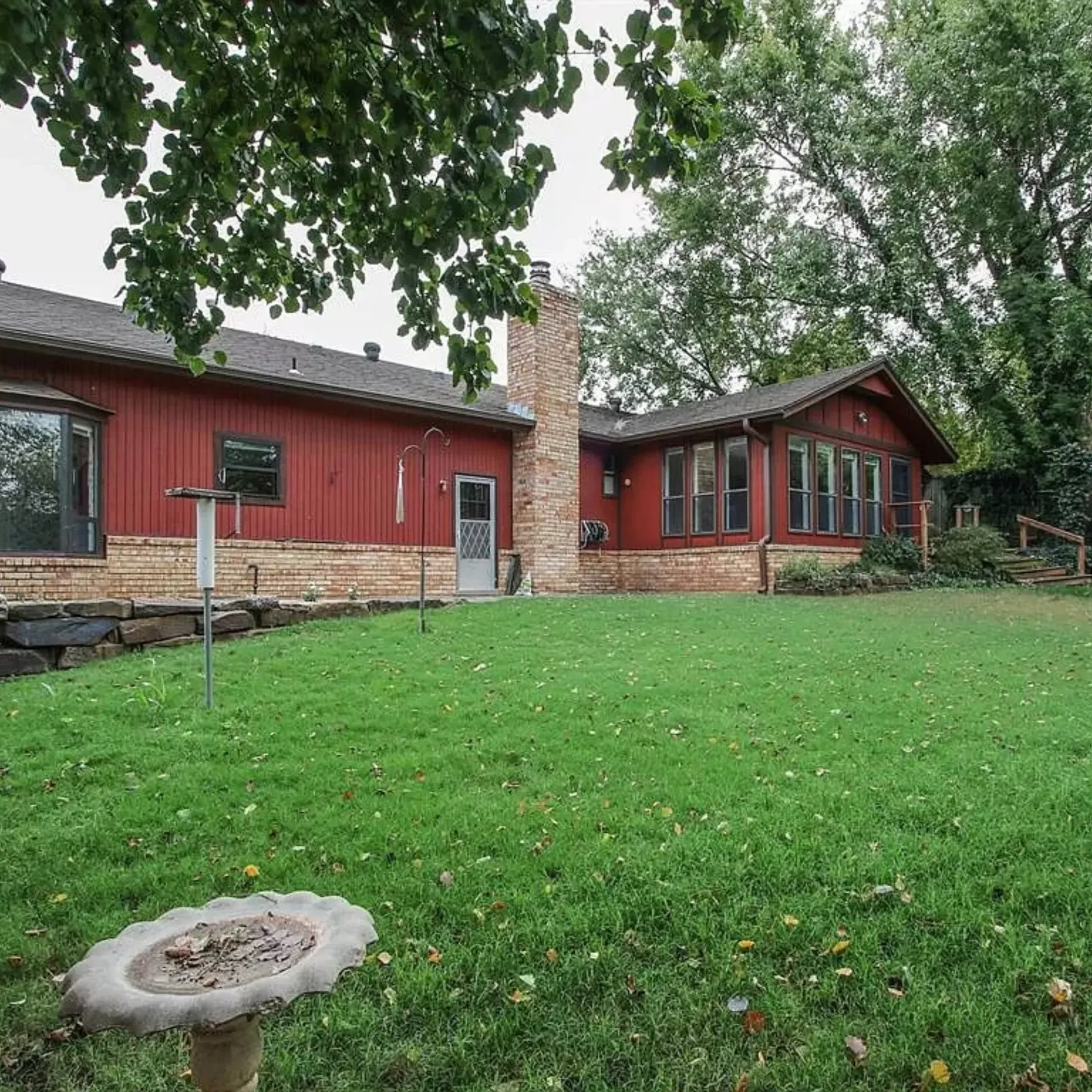 Aarons Repair and Remodel - A large red house with a large lawn in front of it.