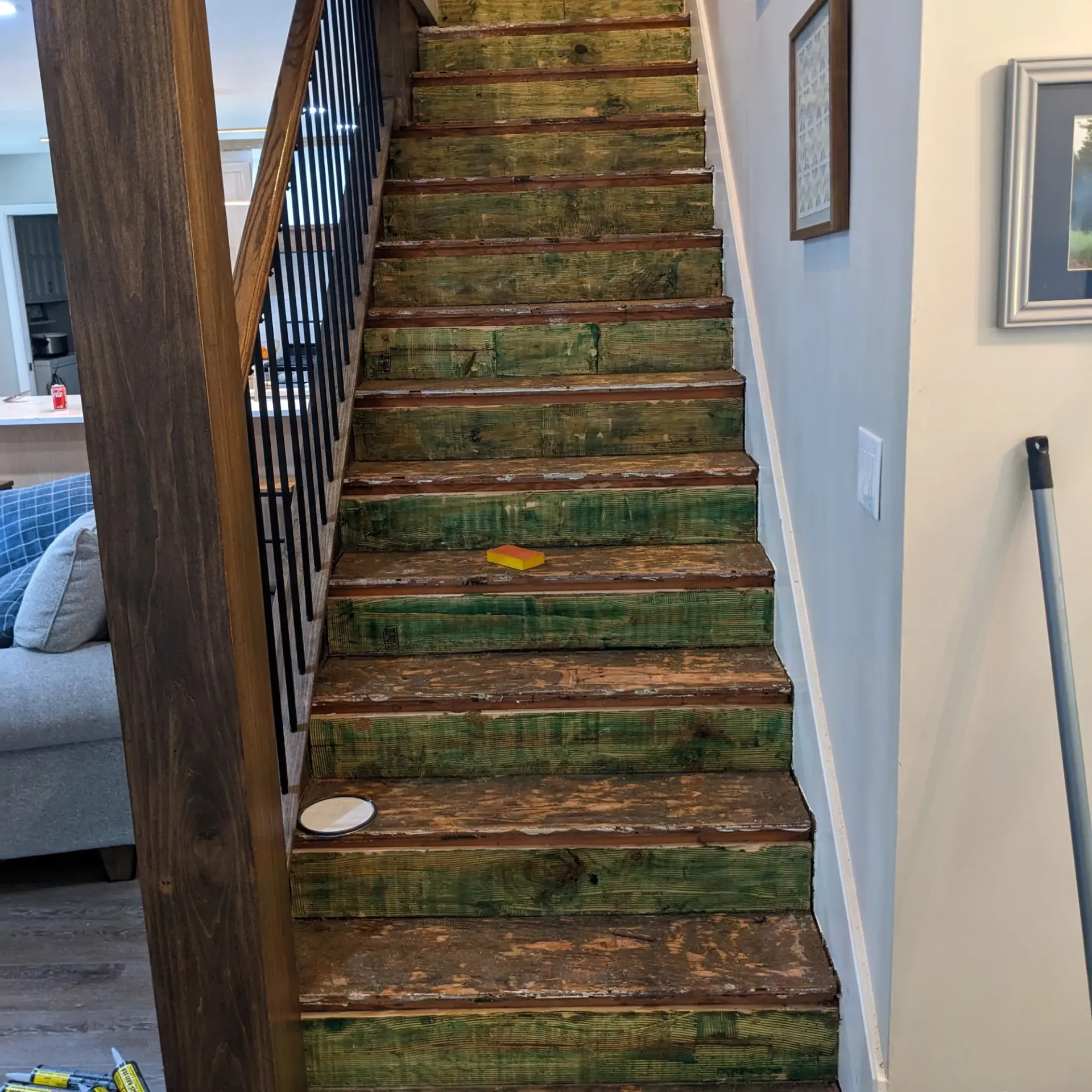 Aarons Repair and Remodel - A wooden staircase with green steps in a house.