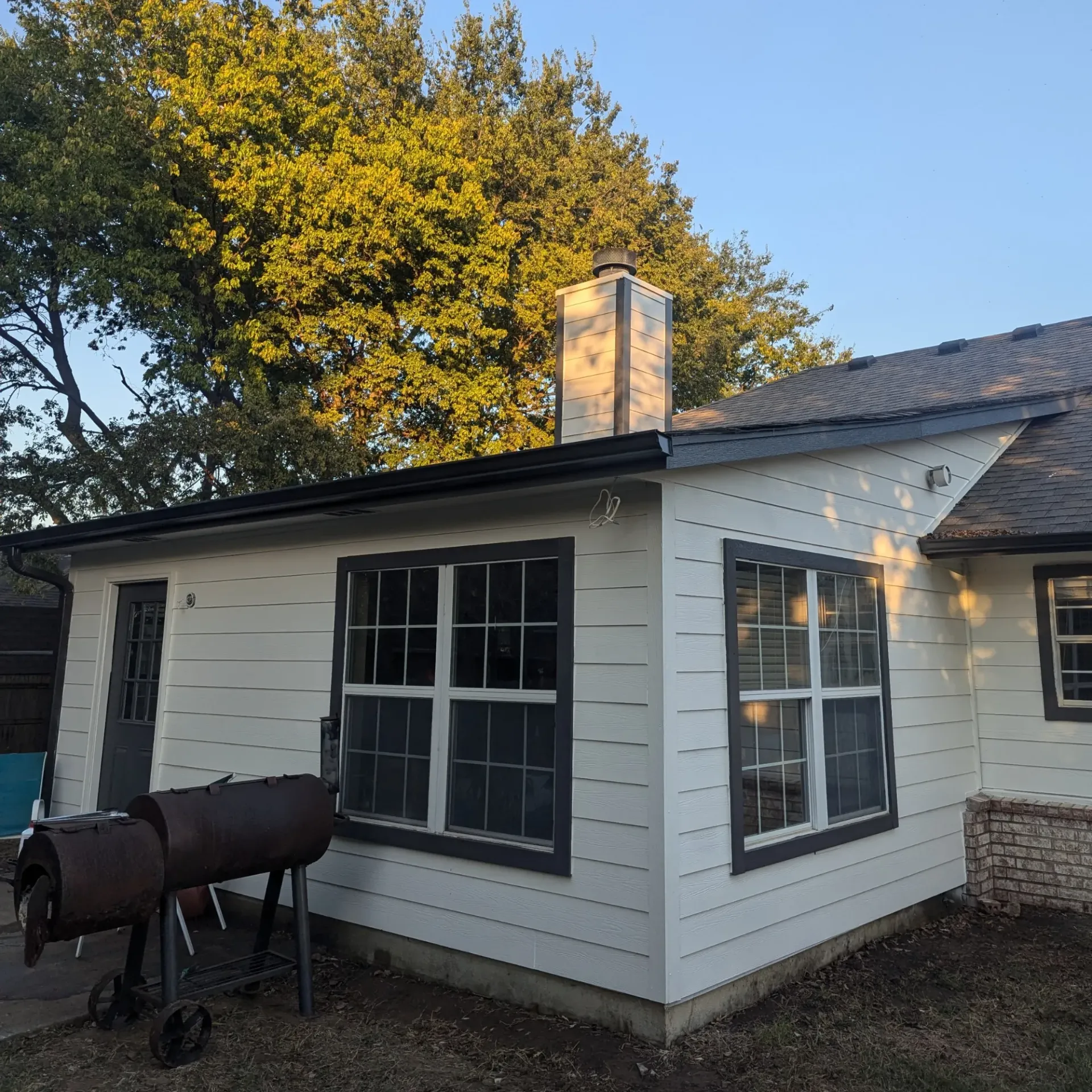 Aarons Repair and Remodel - A white house with a chimney on top of it