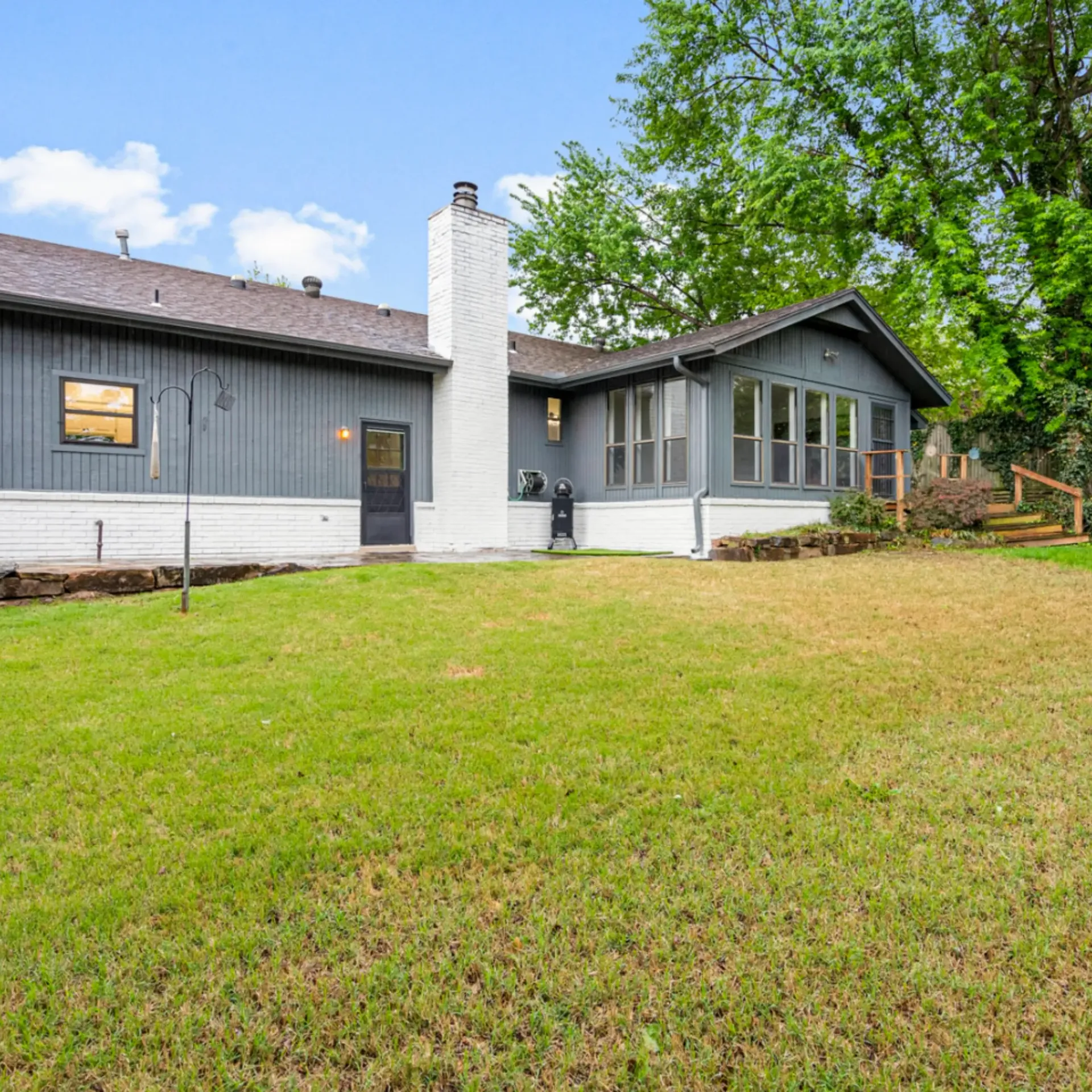 Aarons Repair and Remodel - The back of a house with a large lawn in front of it.