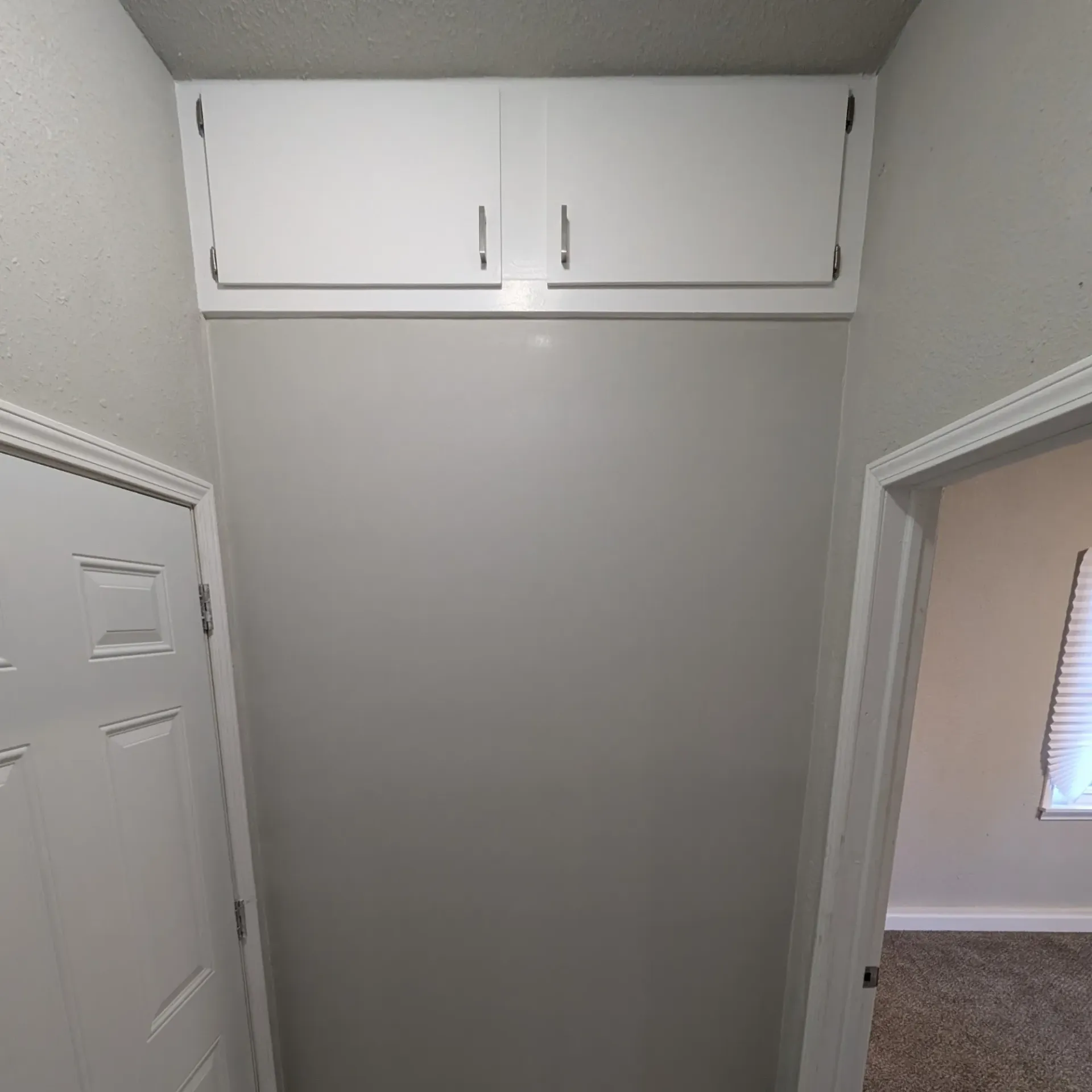 Aarons Repair and Remodel - A hallway with a closet and a door in a house.