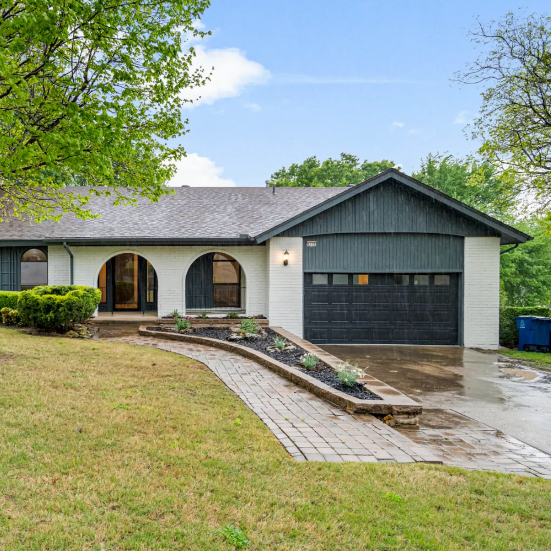 Aarons Repair and Remodel - A white house with a black garage door is for sale.