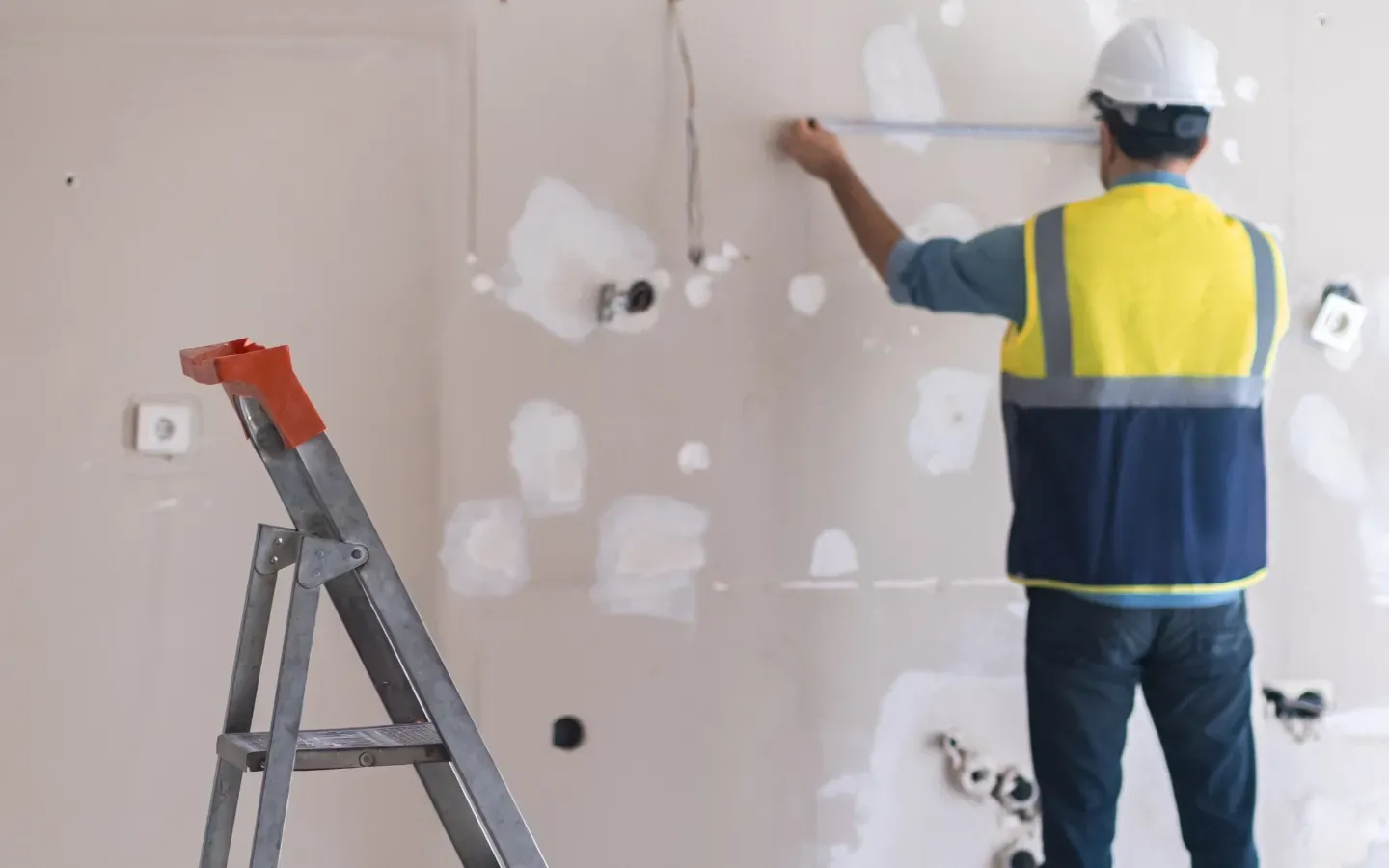 Aarons Remodel and Repair - A man is measuring a wall with a tape measure.