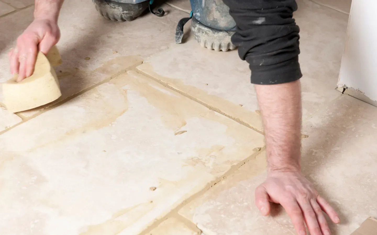 Aarons Remodel and Repair - A man is cleaning a tile floor with a sponge.