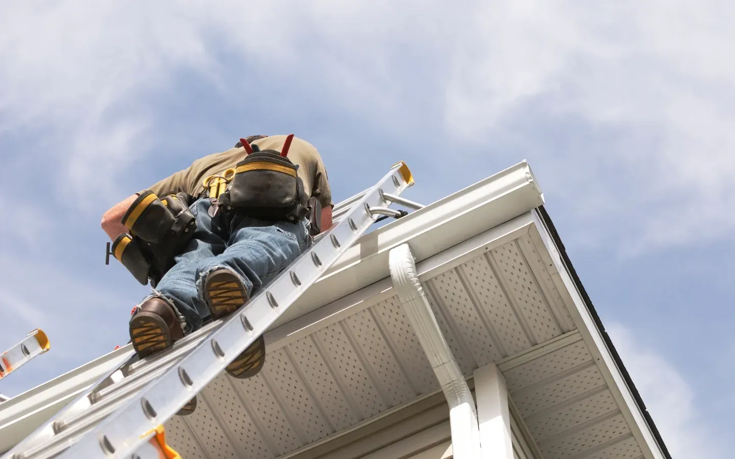 Aarons Remodel and Repair - A man is climbing a ladder on the side of a house.