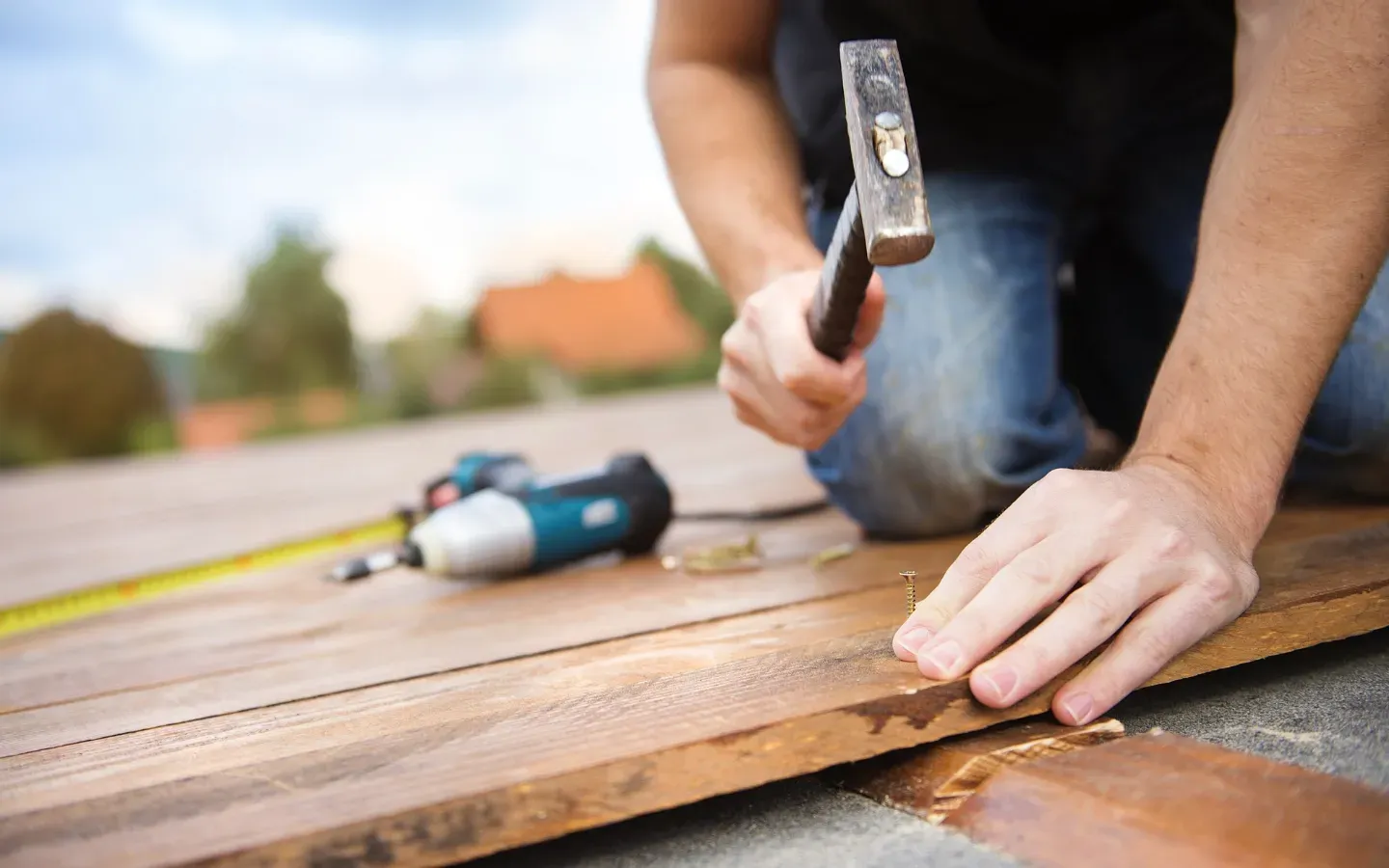 Aarons Remodel and Repair - A man is using a hammer to hammer a nail into a piece of wood.