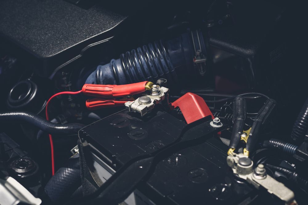A Close Up of a Car Battery With a Charger Attached to It — East Coast Mechanic in Nambucca Heads, NSW