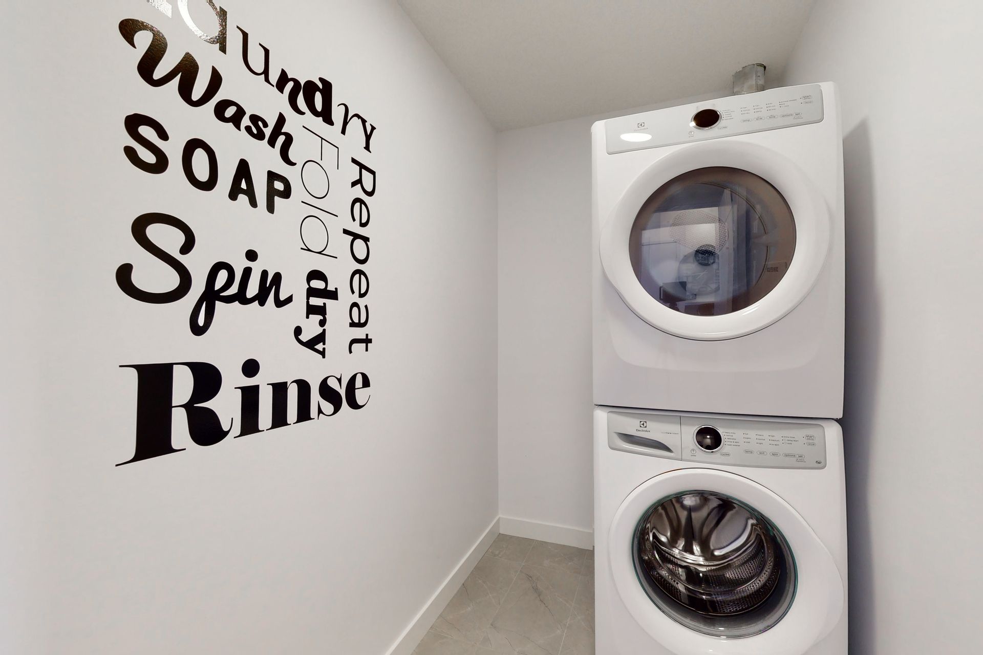 A laundry room with a washer and dryer stacked on top of each other.