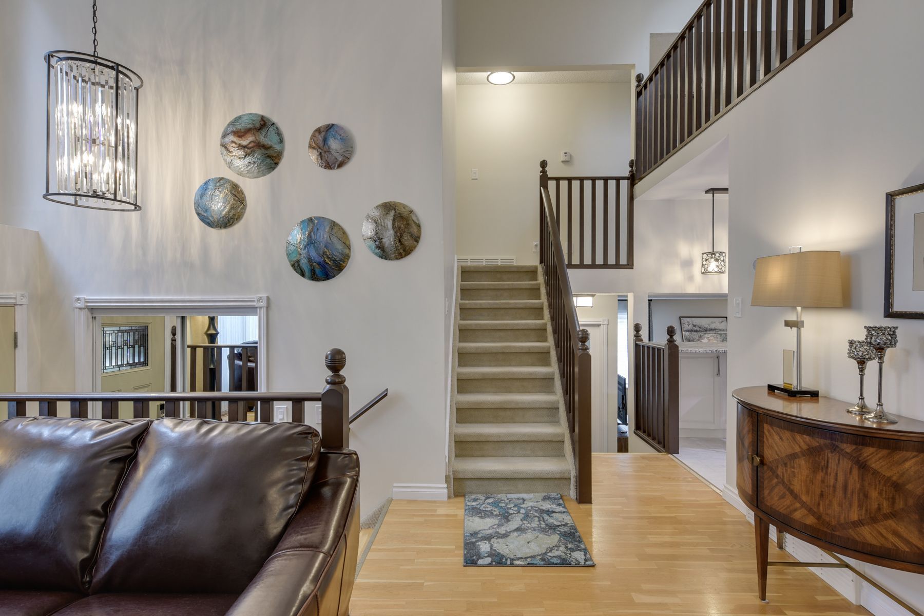 A living room with a couch and stairs leading up to the second floor.