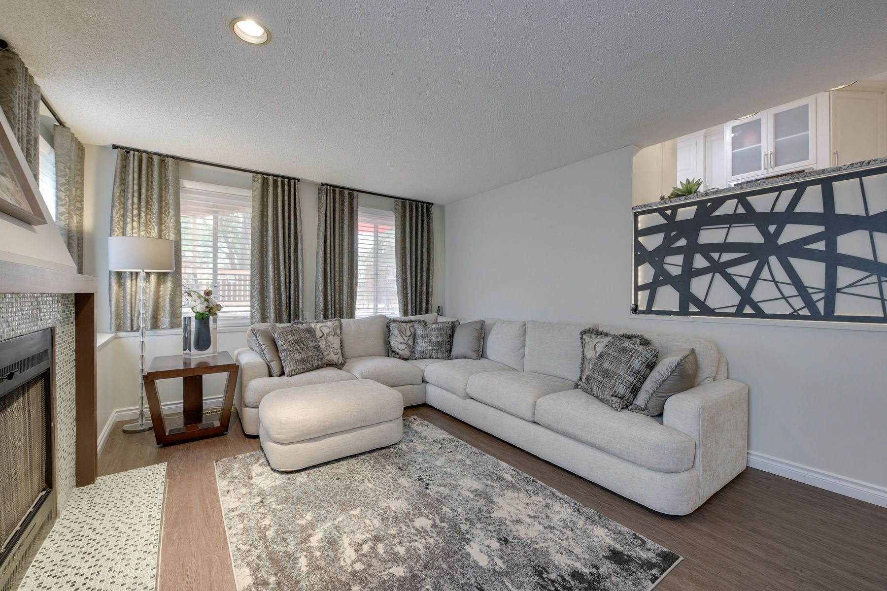 A living room with a large sectional couch and a fireplace
