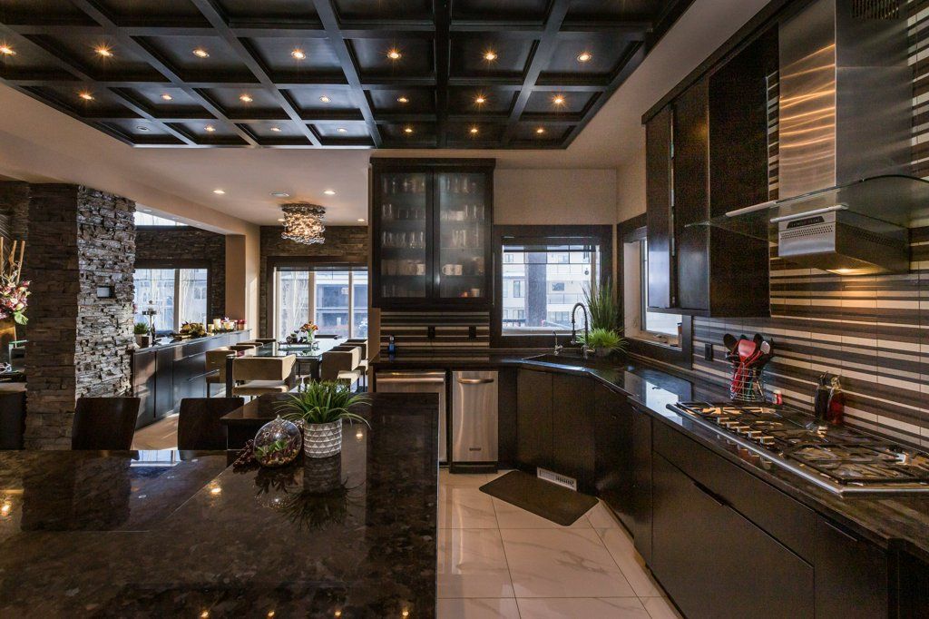 A kitchen with black cabinets and stainless steel appliances