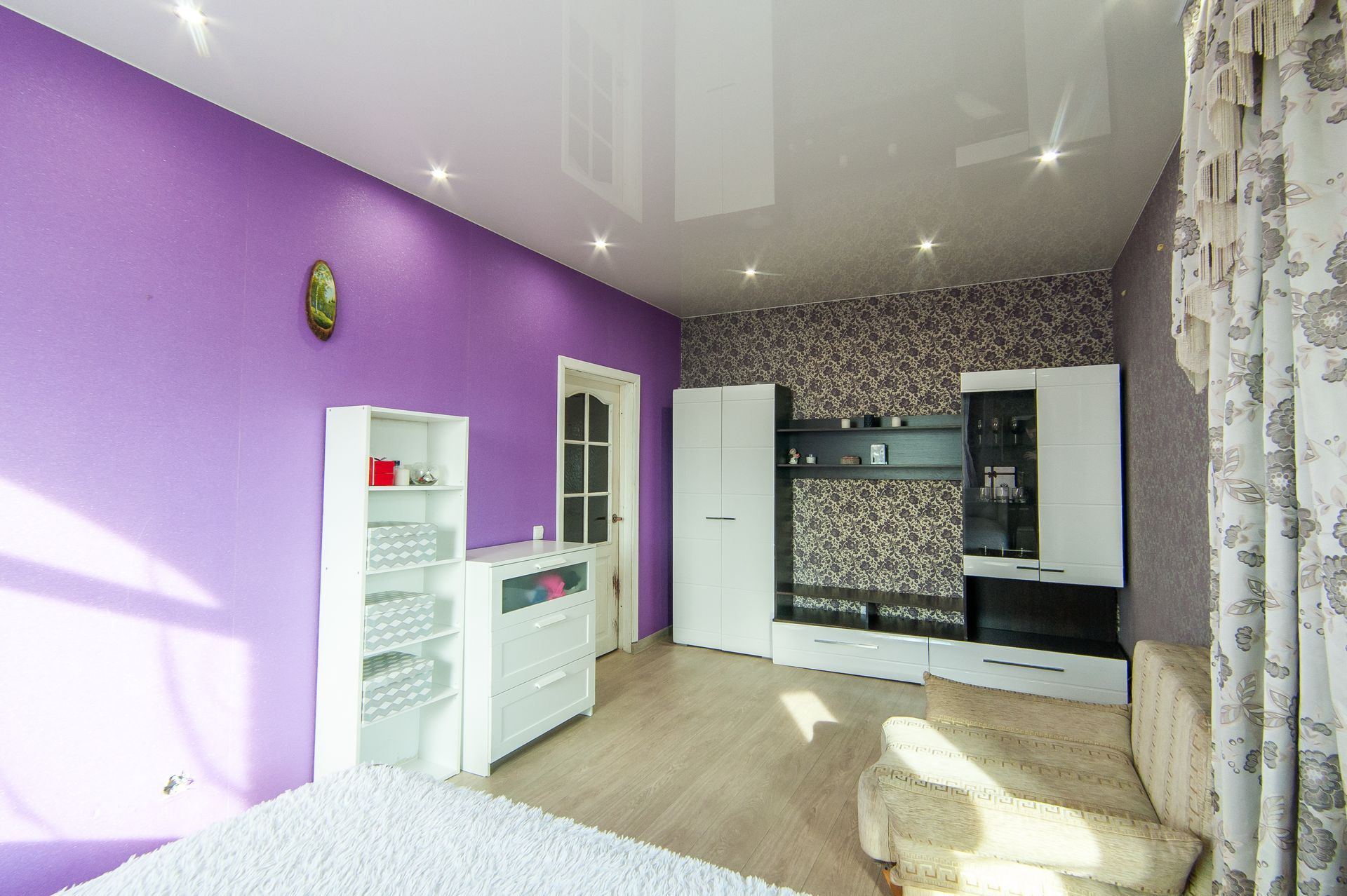 A living room with purple walls and a white ceiling.