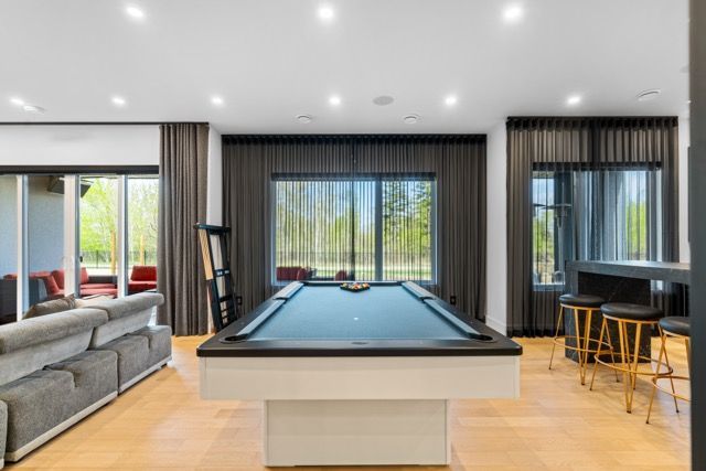There is a pool table in the middle of the living room.