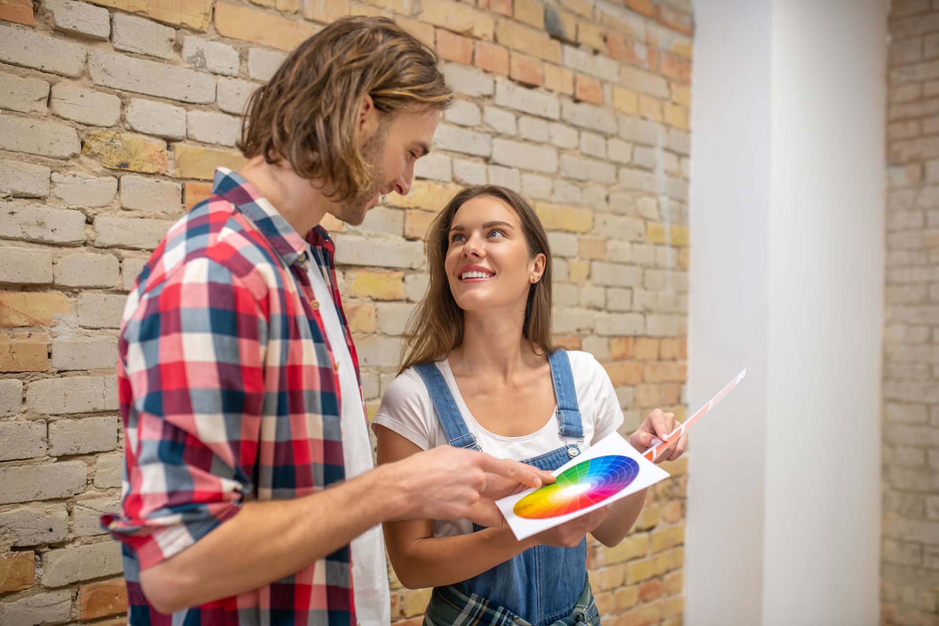 A man and a woman are looking at a color chart.