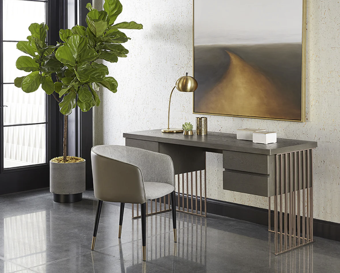There is a desk with a chair and a plant in the room.