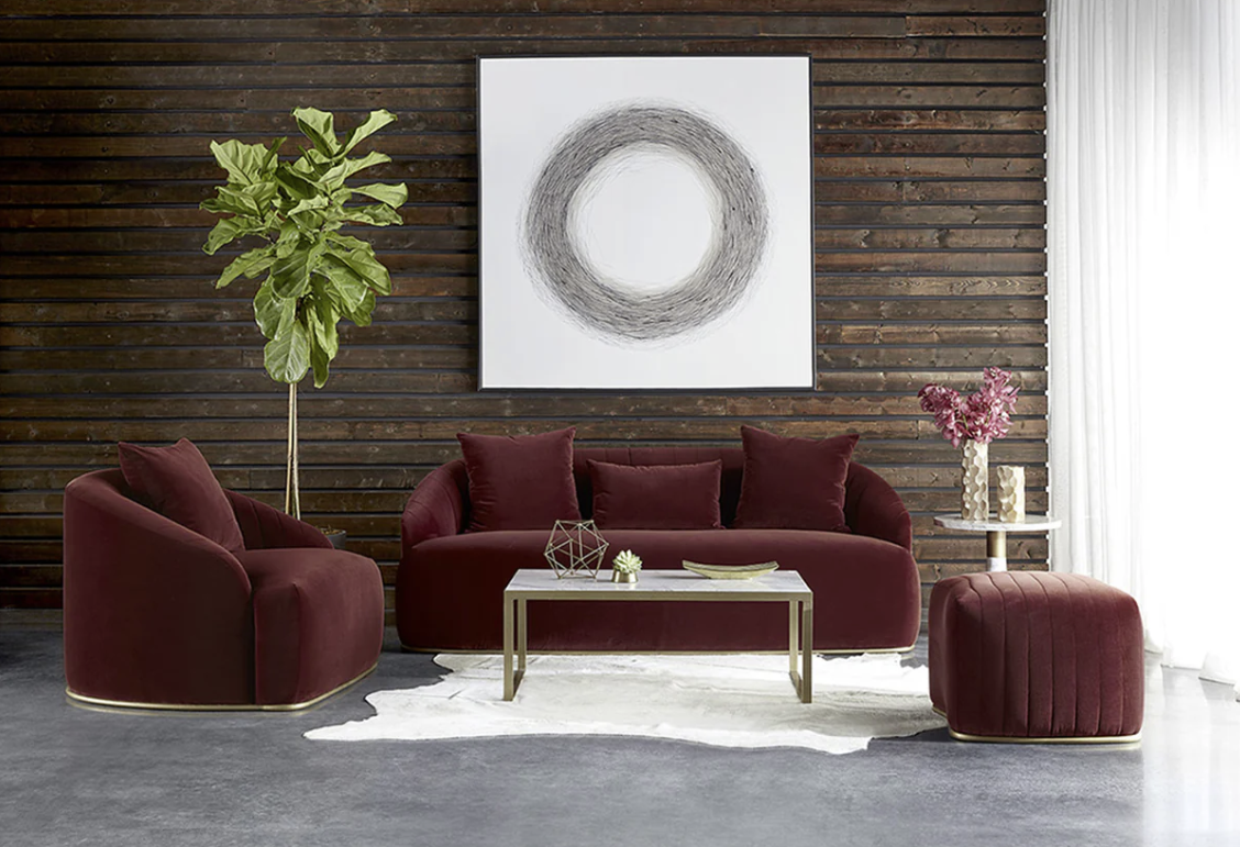 A living room with a couch , chair , coffee table and ottoman.