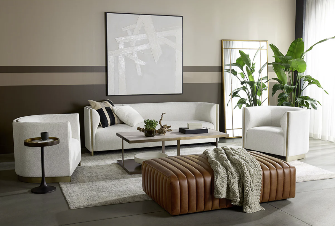 A living room with a couch , chairs , coffee table and ottoman.