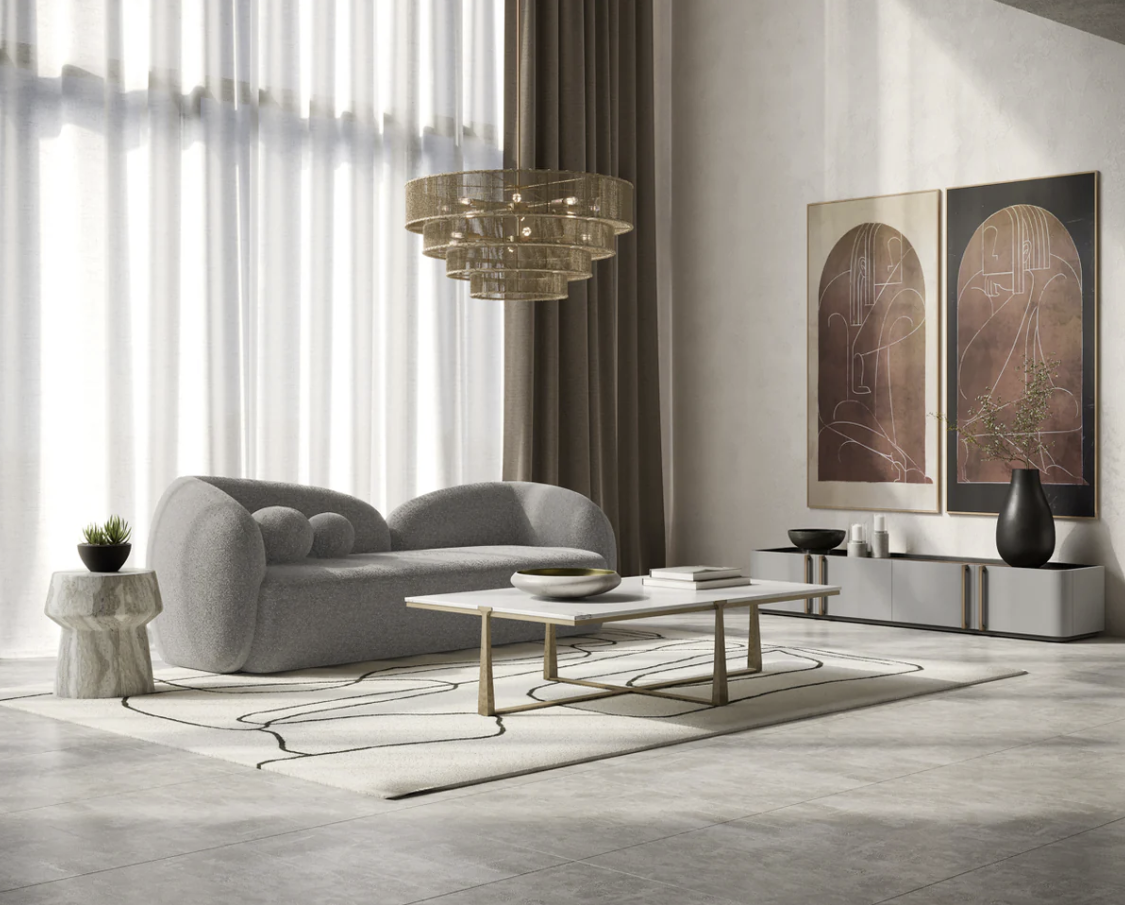 A living room with a couch , coffee table , and two paintings on the wall.