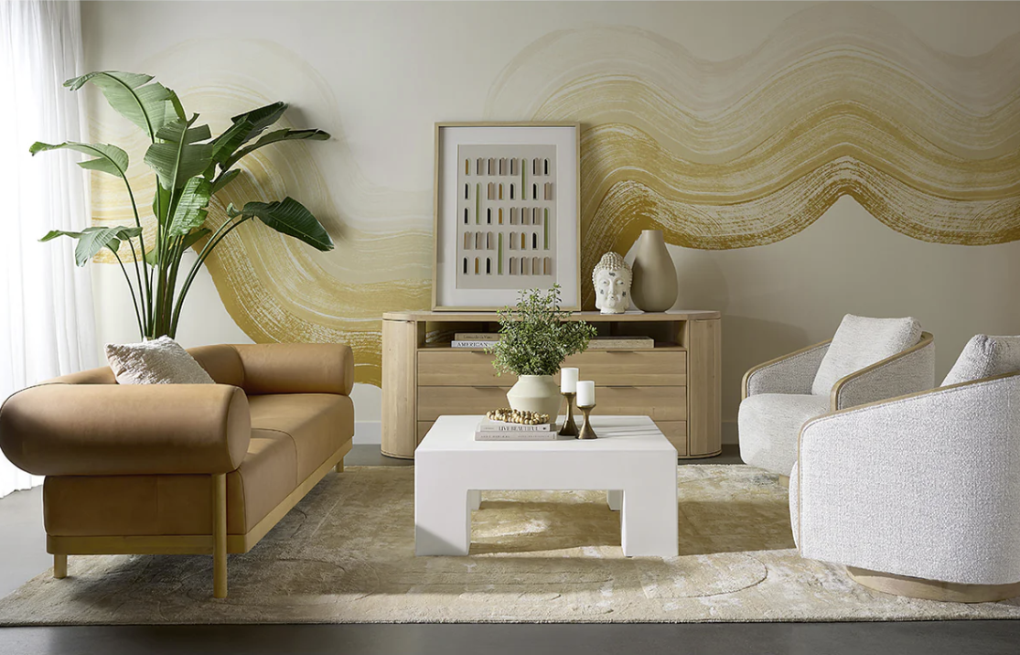 A living room with a couch , chair , coffee table and plant.