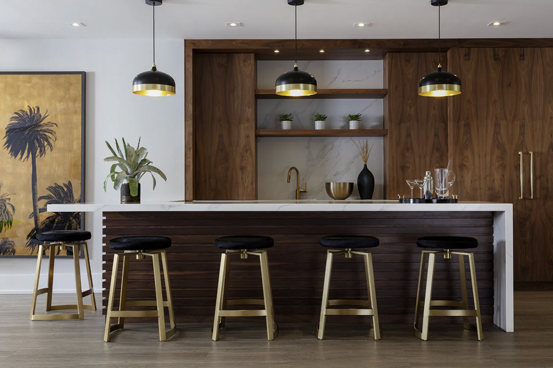 A kitchen with a bar and stools and a painting on the wall