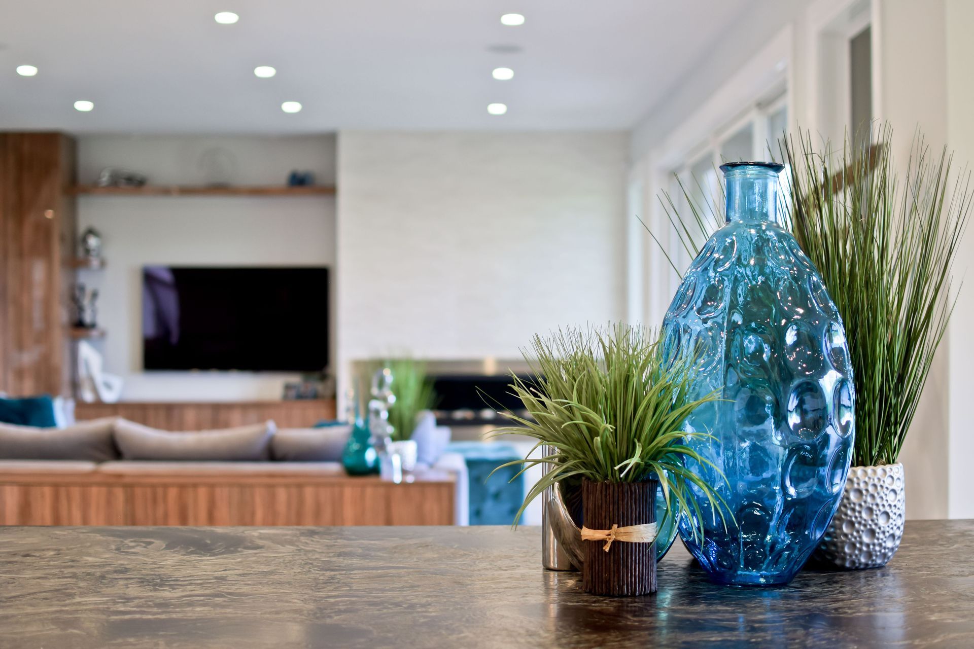 A blue vase is sitting on a counter in a living room.