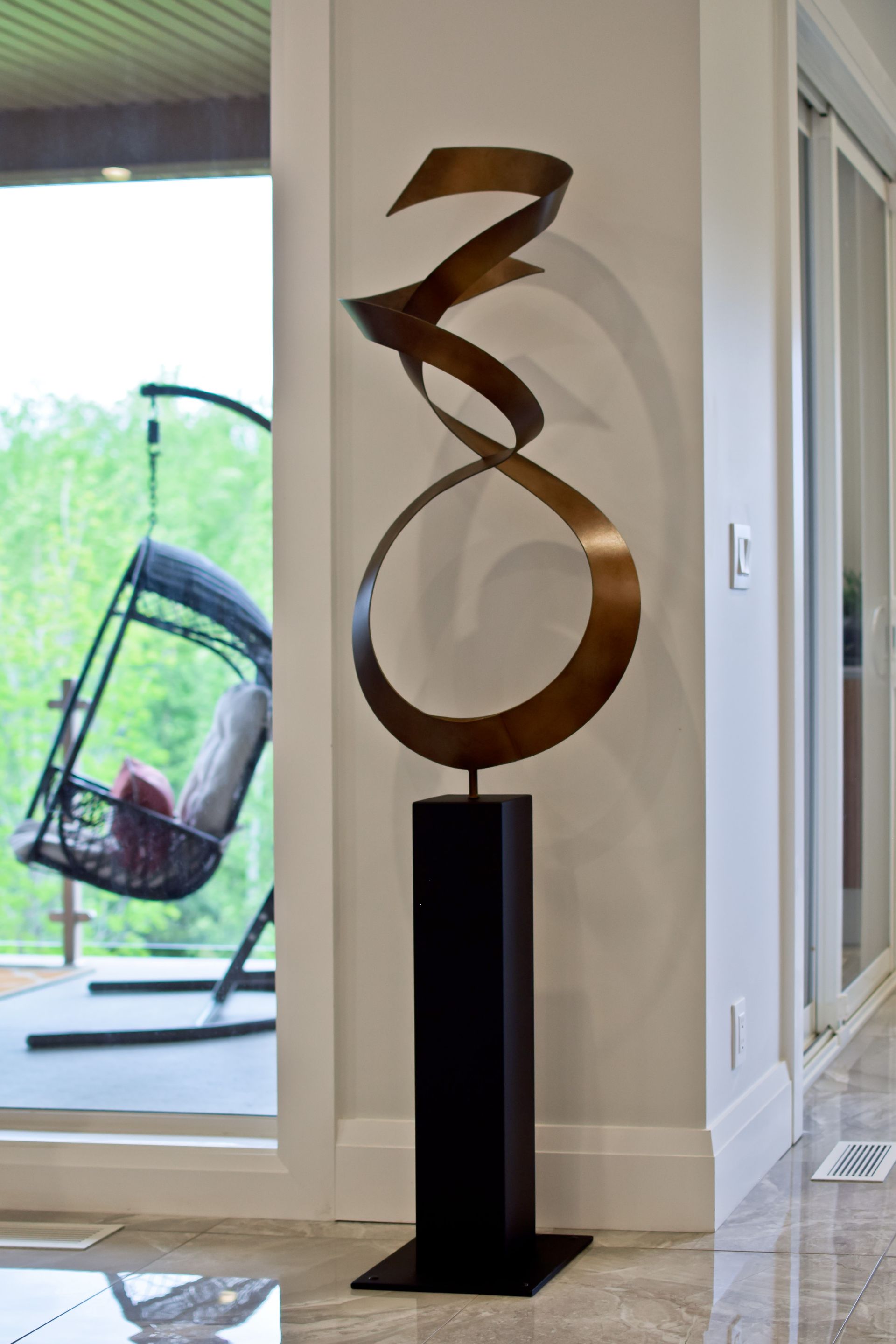 A large sculpture is sitting in a living room next to a window.
