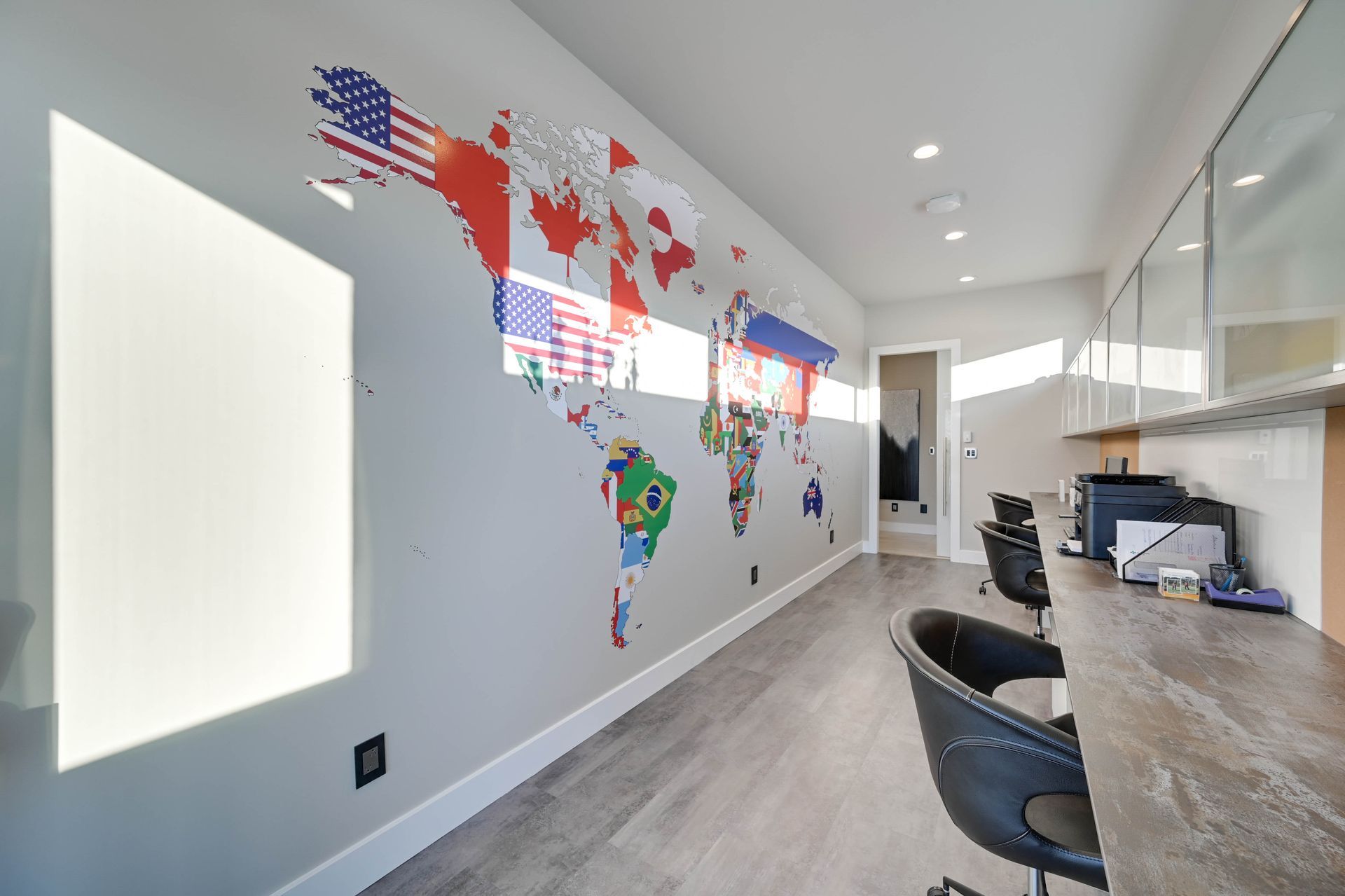 A home office with a large map of the world on the wall.