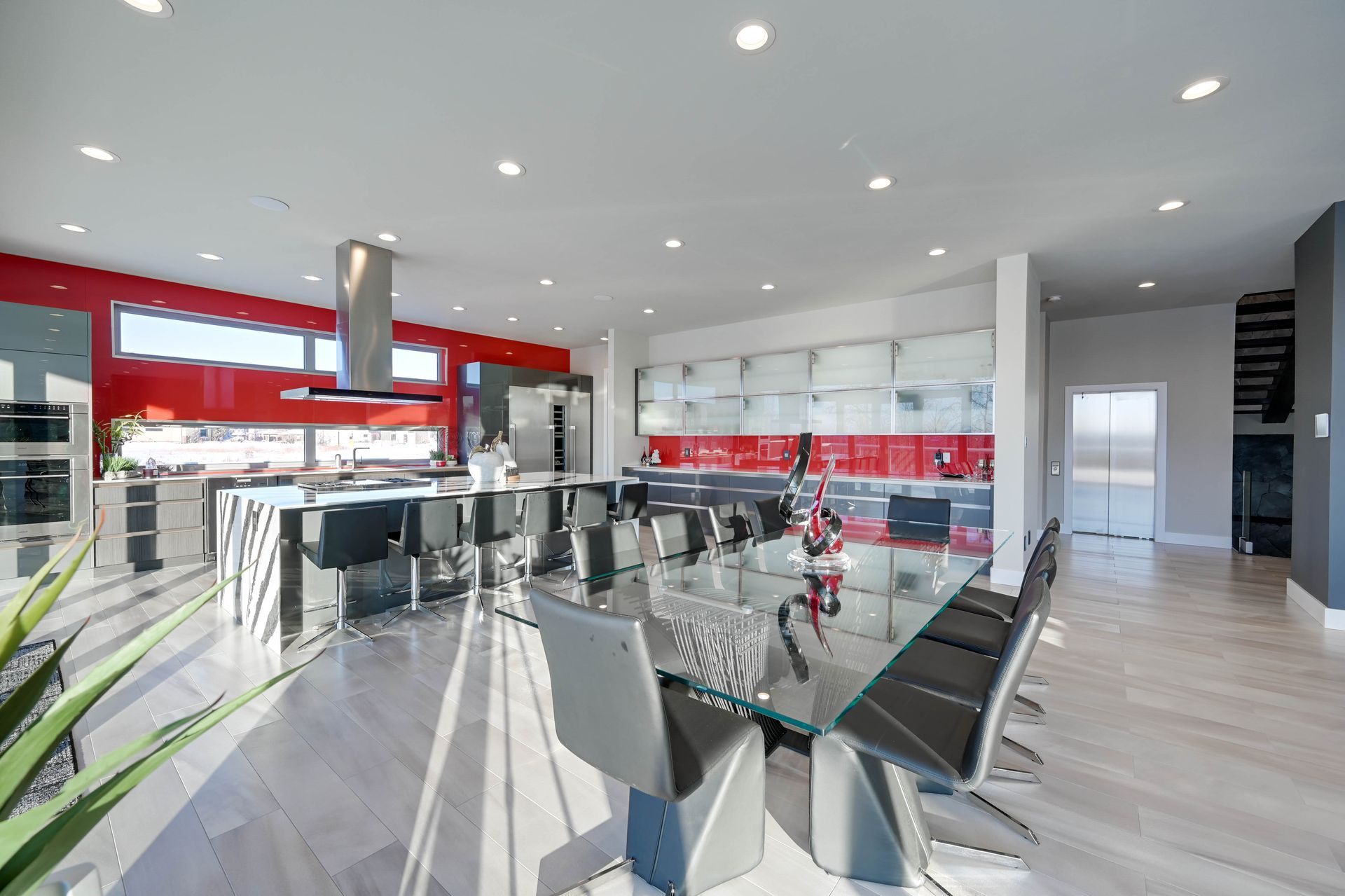 A large kitchen with a glass table and chairs in it.