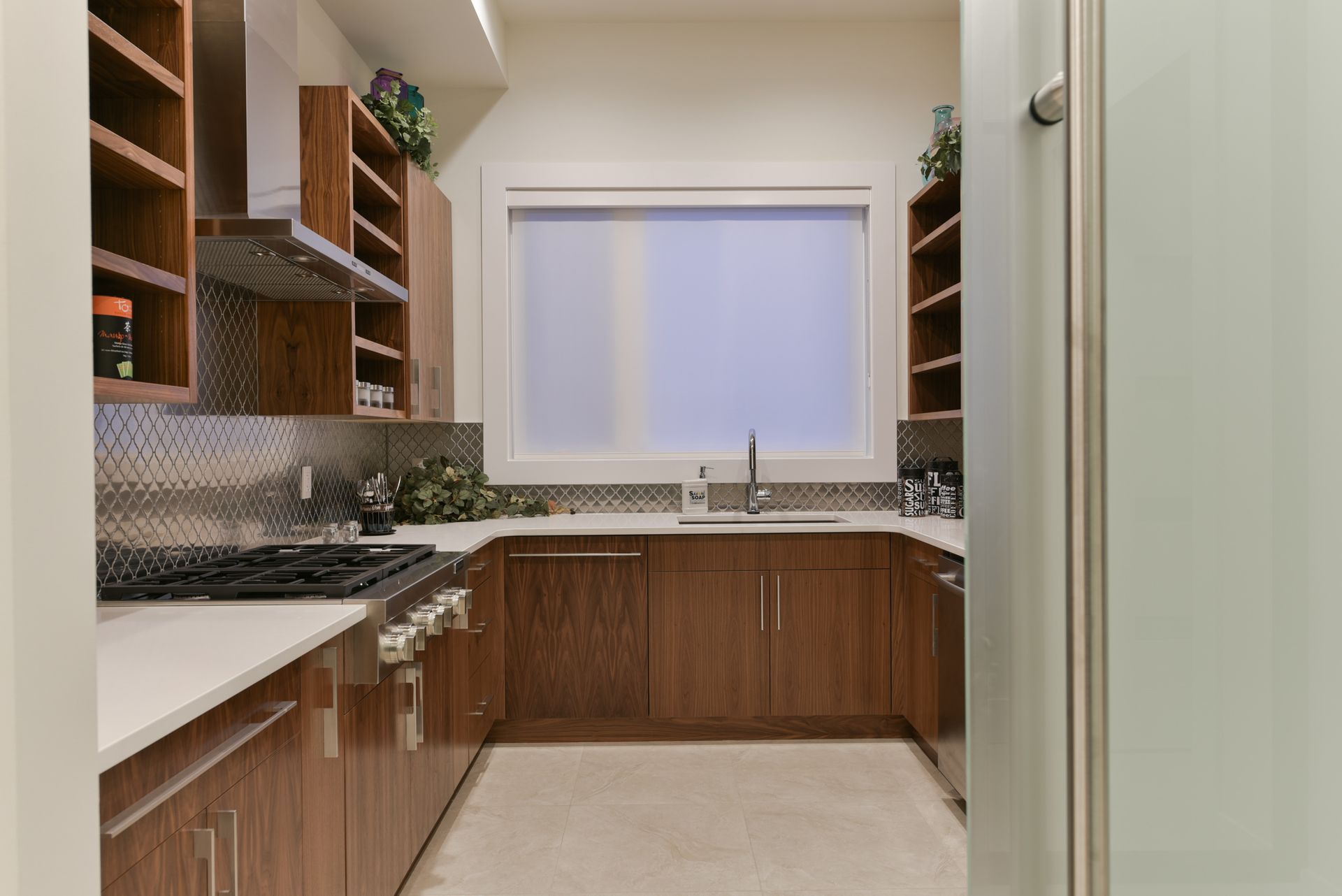 A kitchen with wooden cabinets , stainless steel appliances and a window.