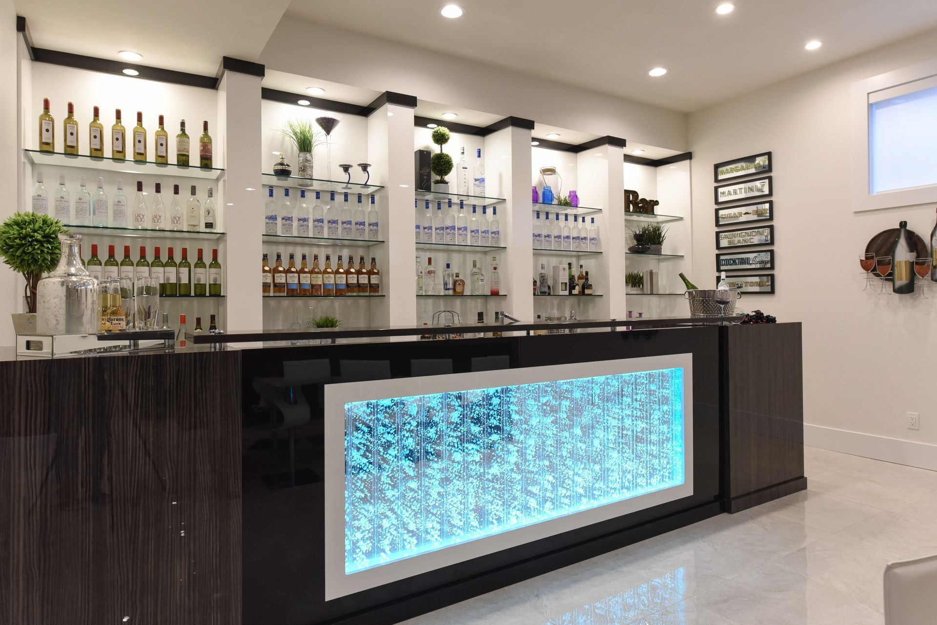 A bar in a basement with bottles and glasses on shelves