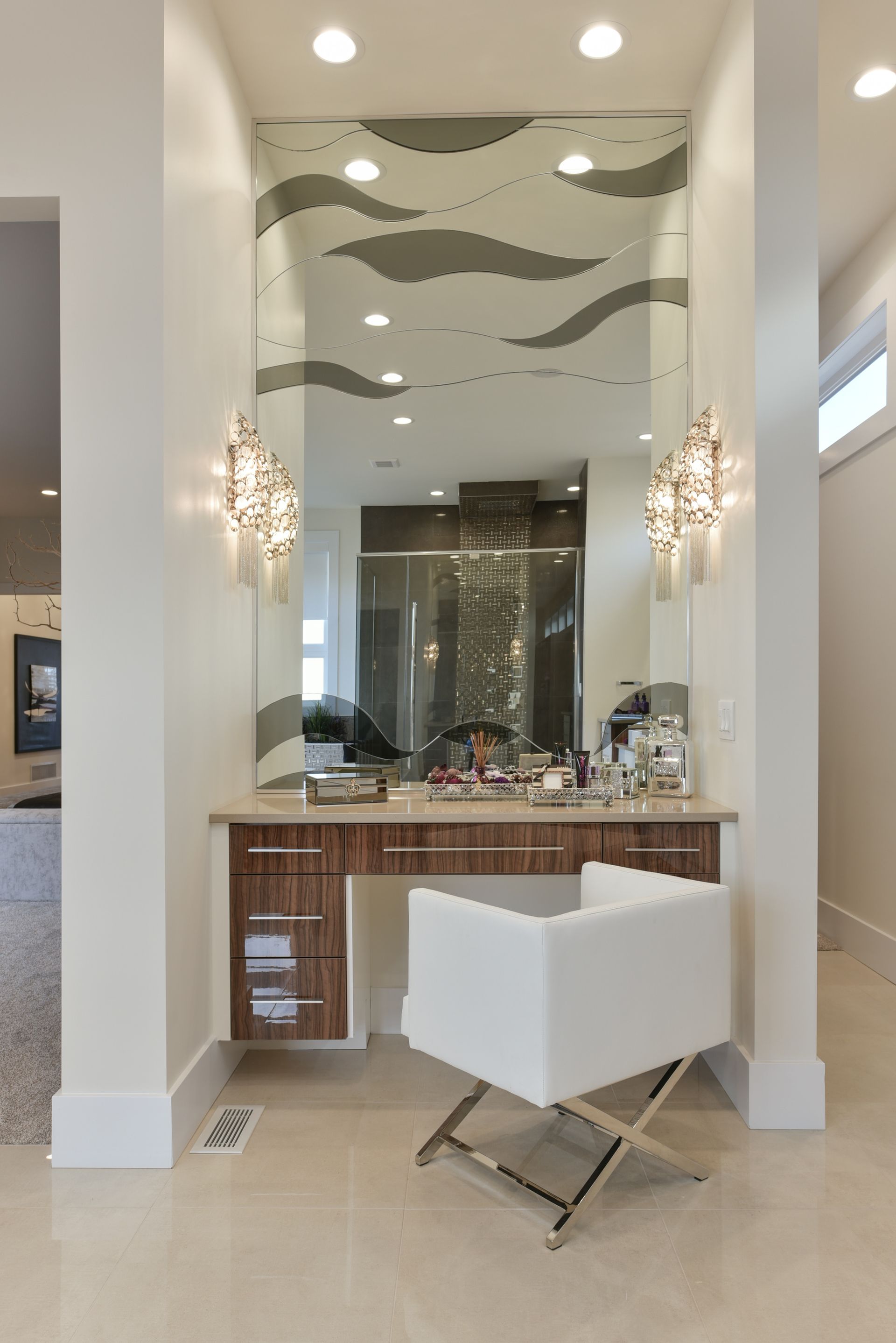 A vanity with a chair and a large mirror in a bathroom.