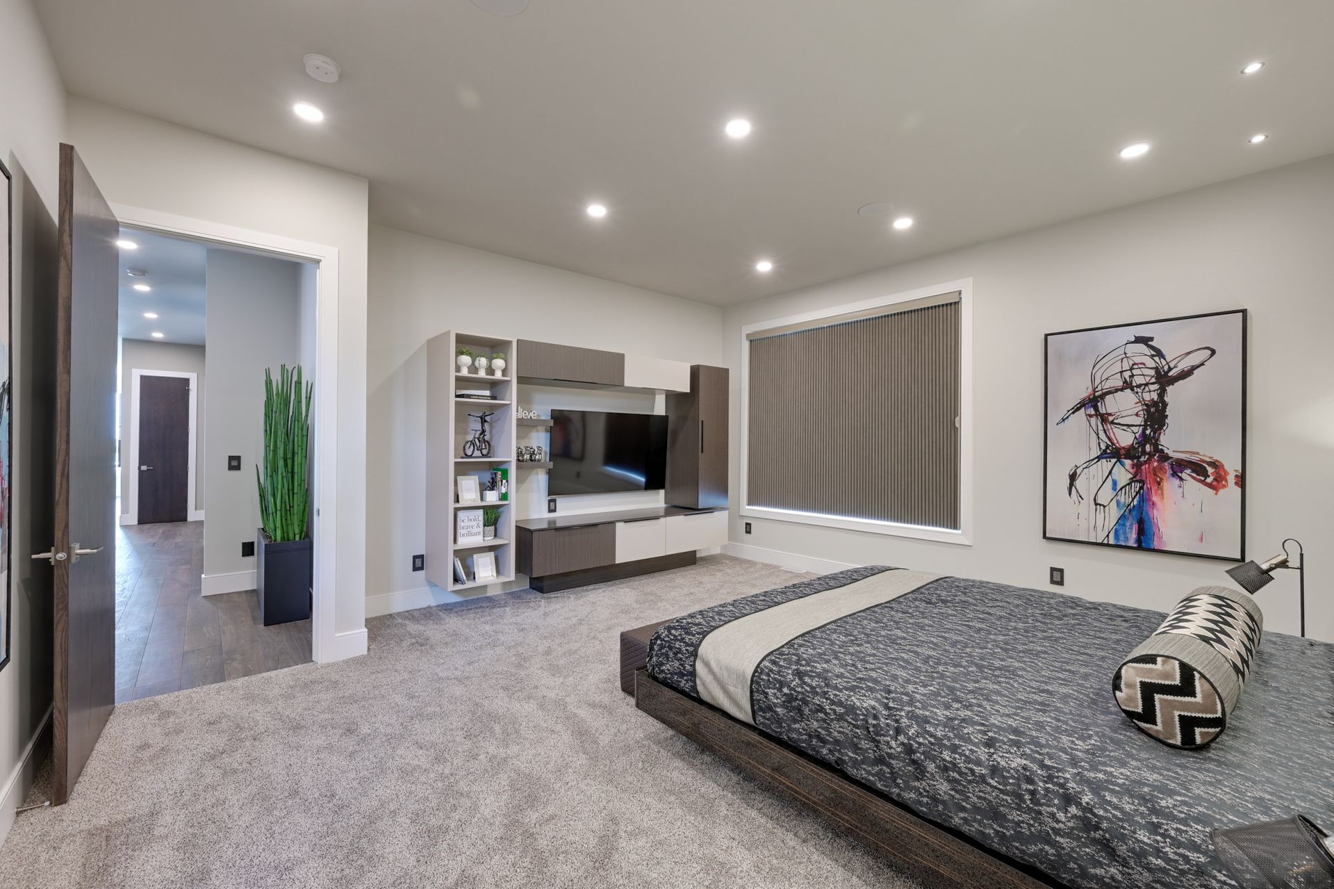 A bedroom with a bed , television , and a painting on the wall.