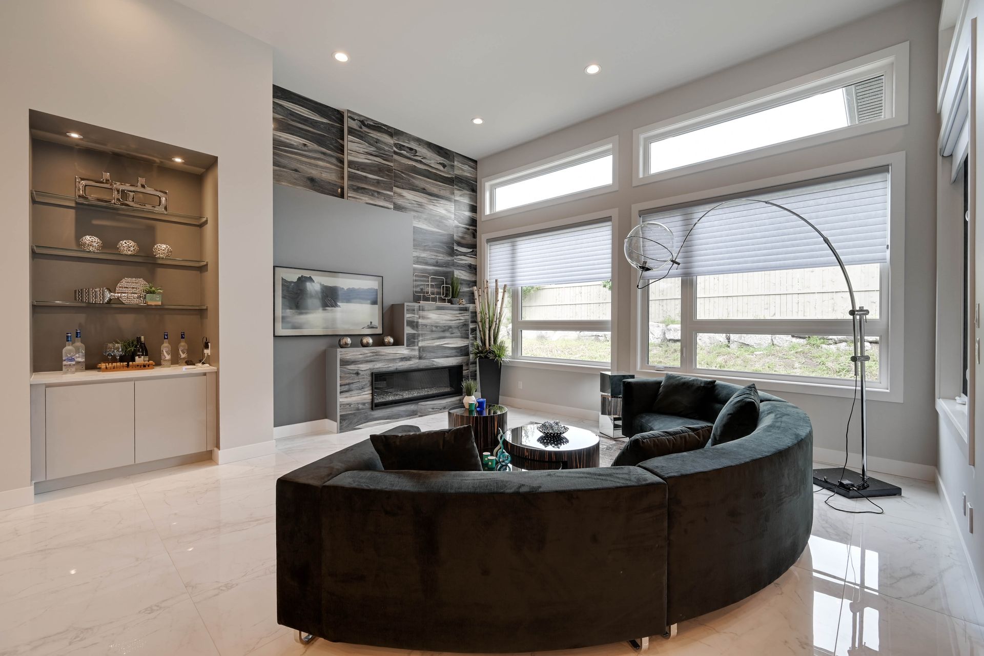 A living room with a curved couch and a fireplace.