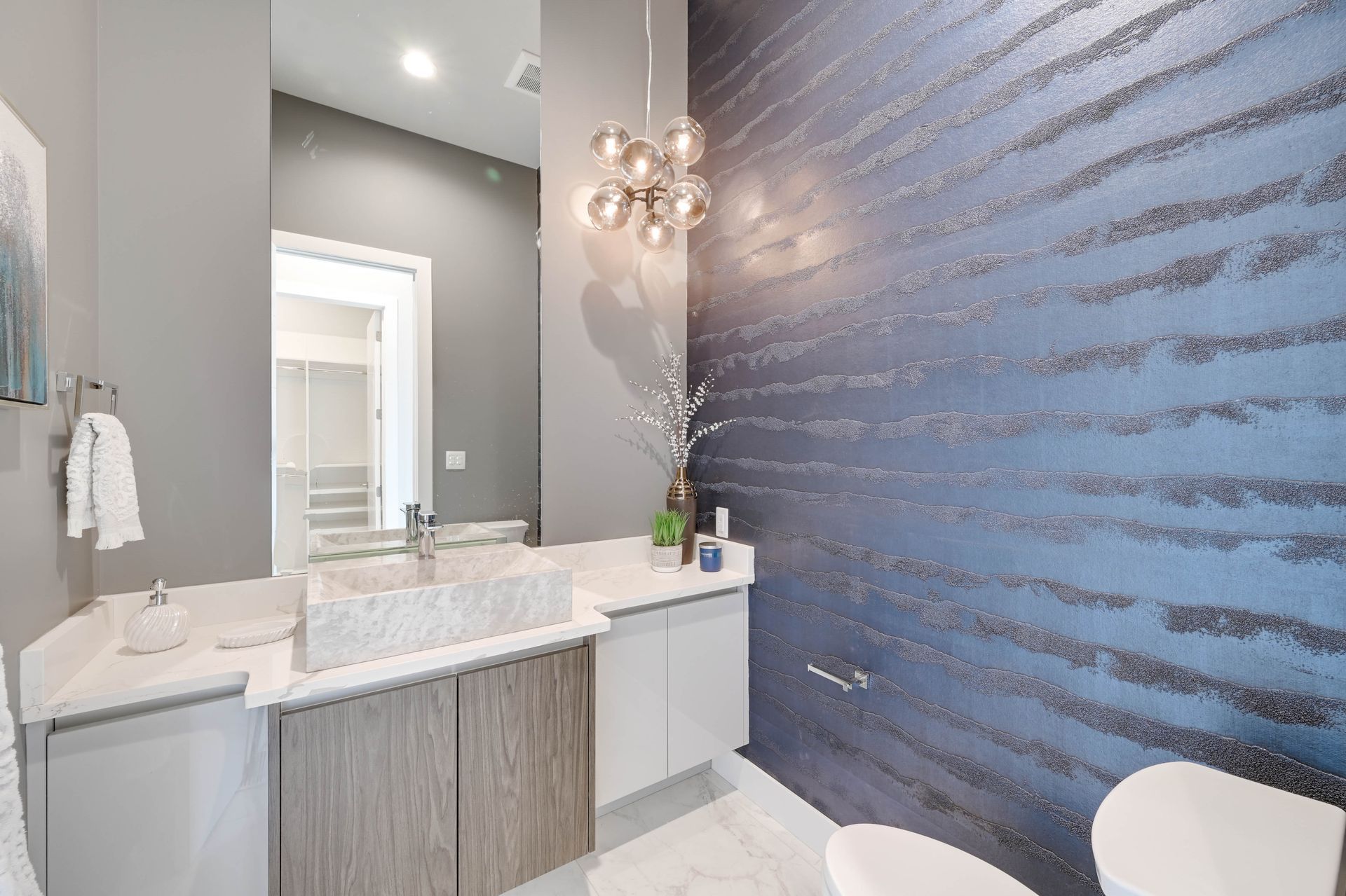 A bathroom with a sink , toilet and mirror.