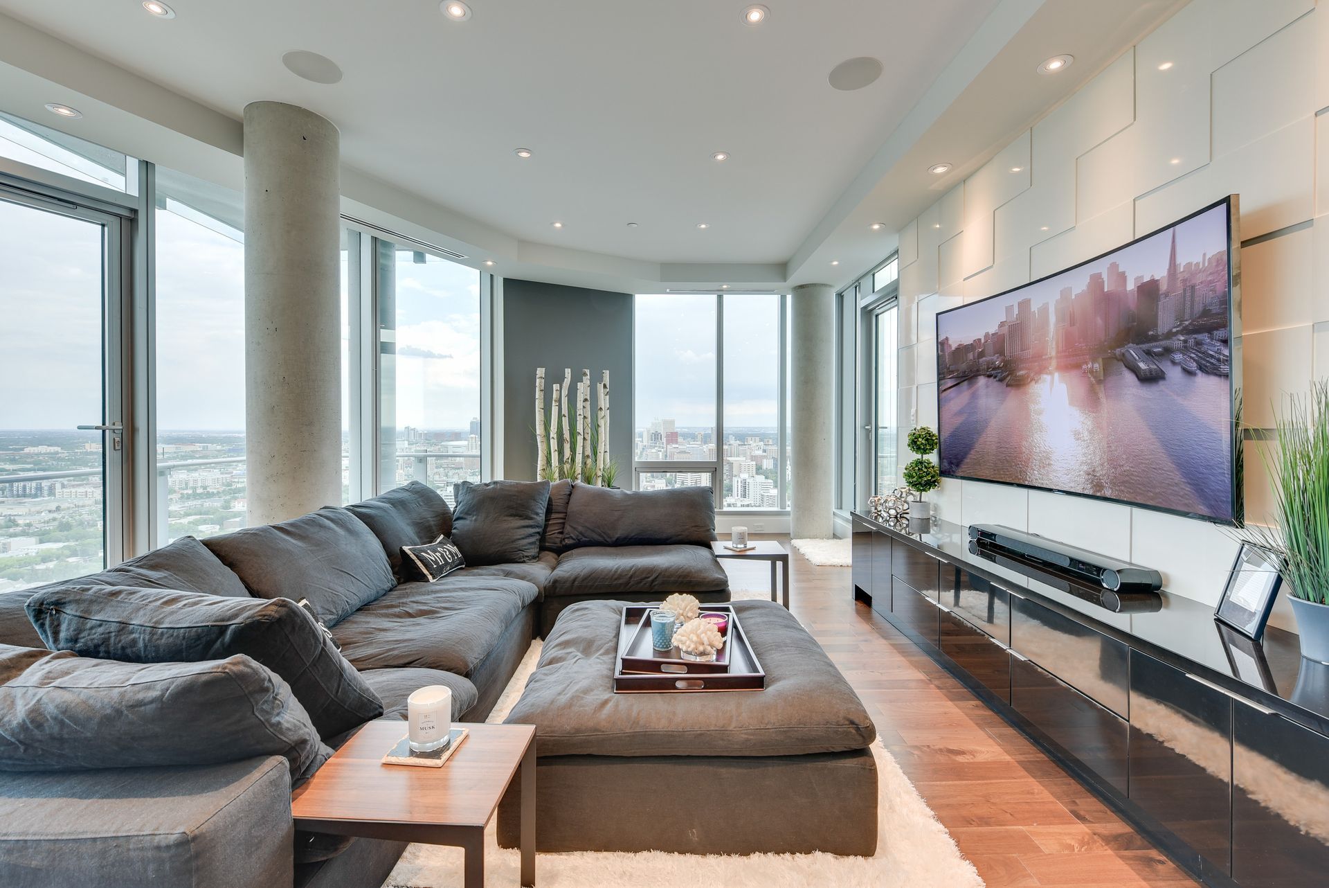 A living room with a large sectional couch and a flat screen tv
