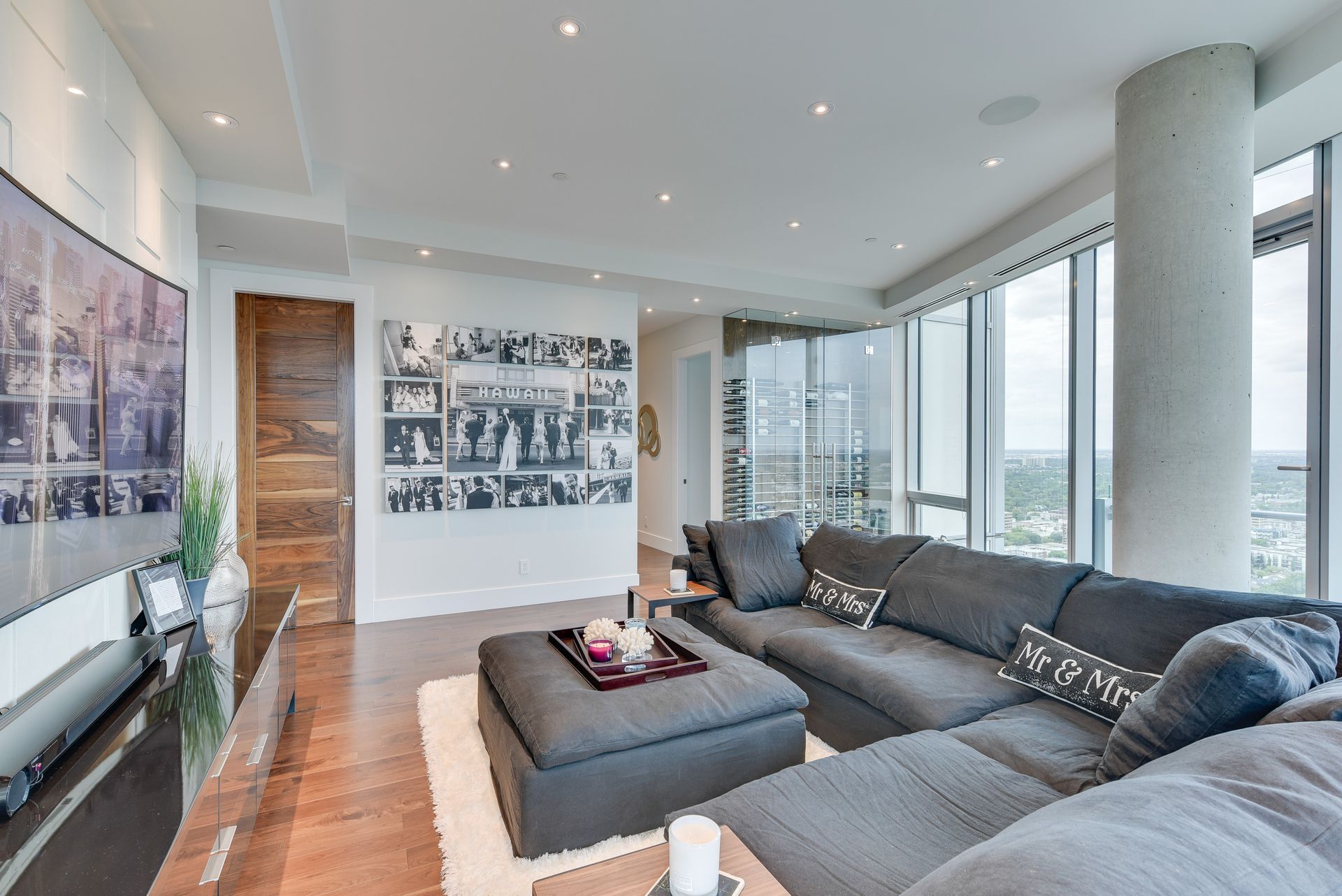 A living room with a couch , ottoman , and television.