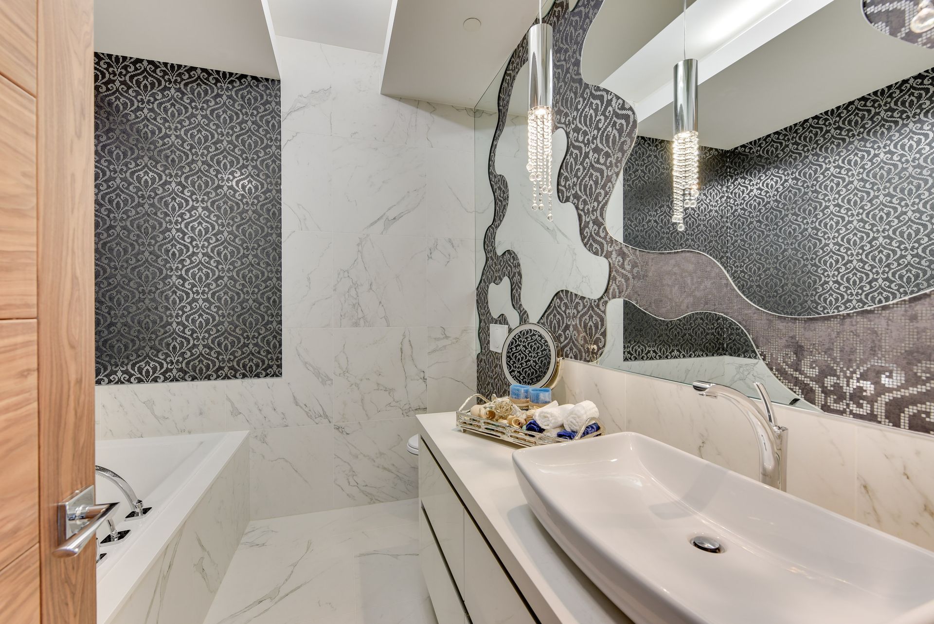 A bathroom with a sink , tub and mirror.
